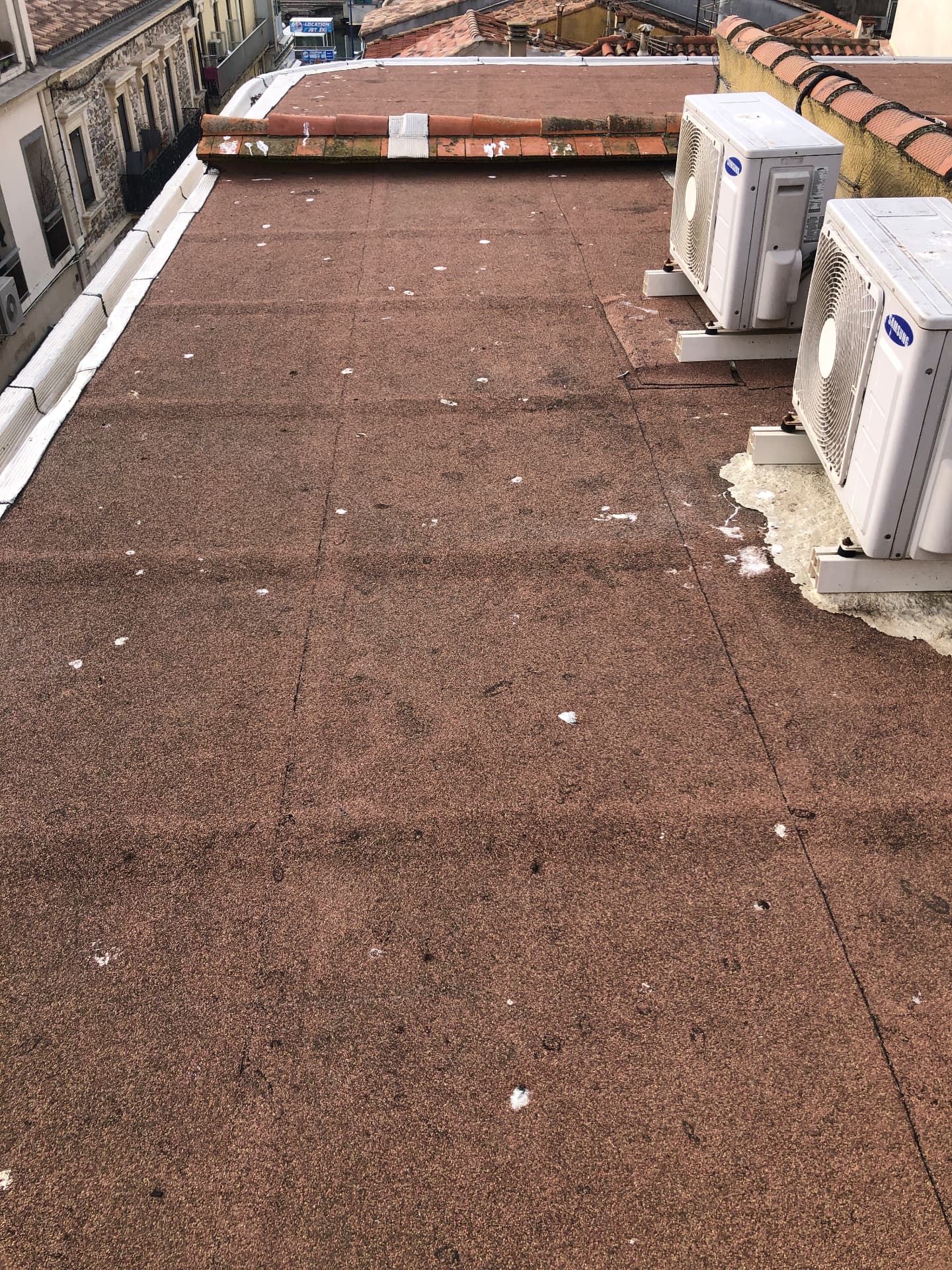 Étanchéur appliquant une membrane bitumineuse au chalumeau sur une toiture-terrasse